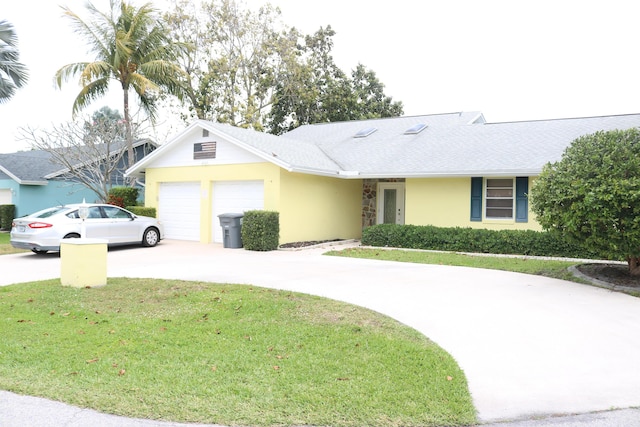 ranch-style home featuring stucco siding, driveway, roof with shingles, an attached garage, and a front yard