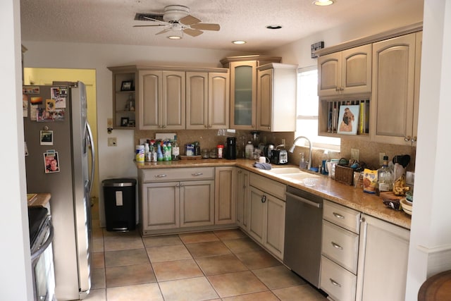 kitchen with light tile patterned floors, a sink, ceiling fan, stainless steel appliances, and tasteful backsplash