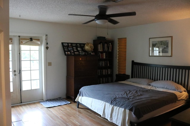 bedroom featuring light wood finished floors, a textured ceiling, and ceiling fan