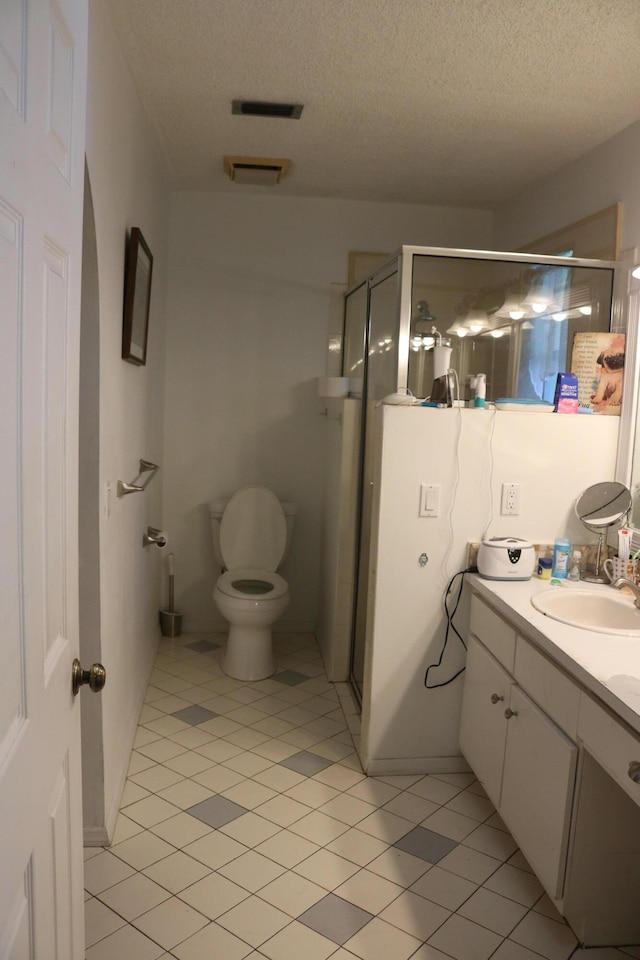 bathroom featuring visible vents, toilet, a textured ceiling, a shower stall, and vanity