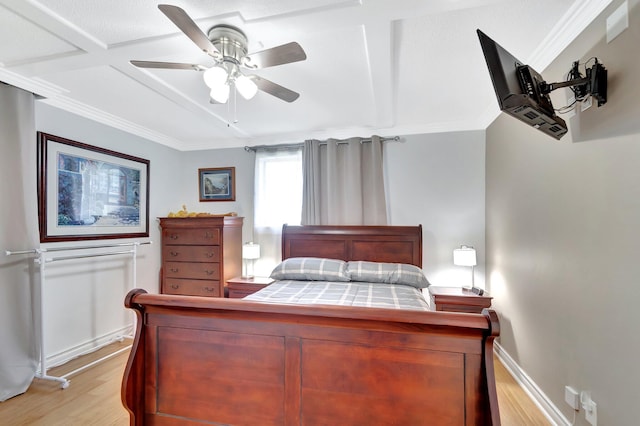 bedroom featuring light wood finished floors, ceiling fan, crown molding, and baseboards