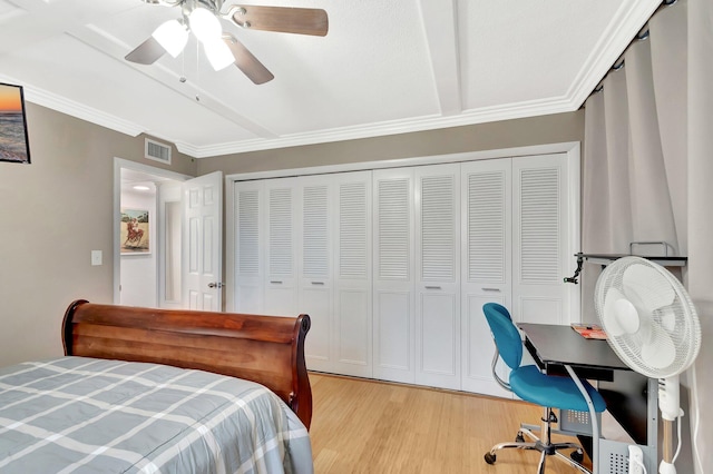 bedroom featuring visible vents, light wood-type flooring, a closet, and ornamental molding