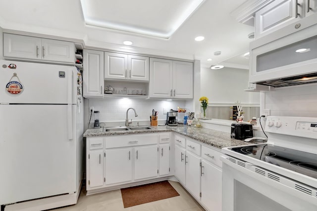 kitchen featuring decorative backsplash, recessed lighting, white cabinets, white appliances, and a sink