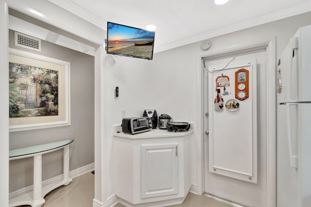 bar with a toaster, visible vents, crown molding, and baseboards