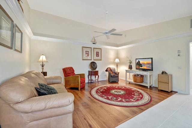 living room featuring wood finished floors, baseboards, visible vents, ceiling fan, and ornamental molding