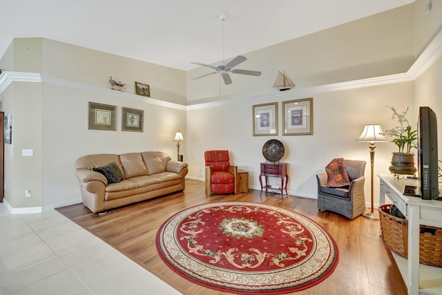 living room with baseboards, crown molding, wood finished floors, and ceiling fan