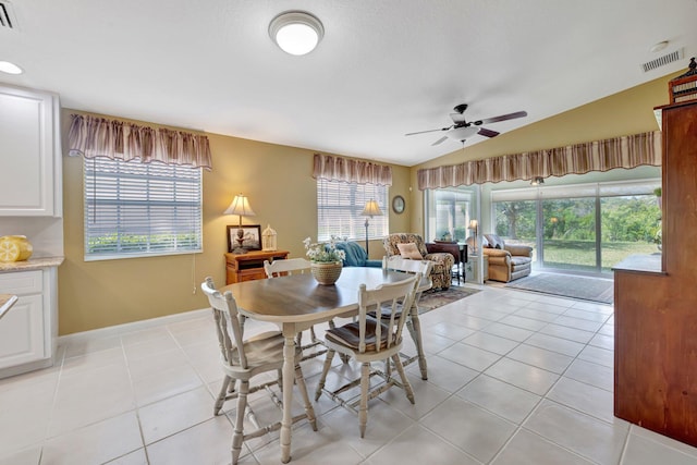 dining space with vaulted ceiling, a ceiling fan, visible vents, and light tile patterned floors