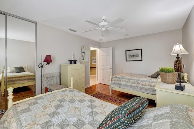 bedroom with a ceiling fan, visible vents, a closet, and wood finished floors