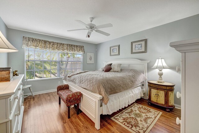bedroom featuring baseboards, light wood-style floors, and ceiling fan