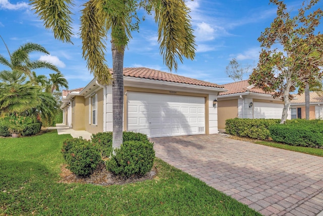 view of front of house featuring stucco siding, a front yard, an attached garage, and a tiled roof