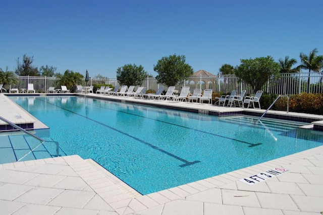 community pool with a patio and fence