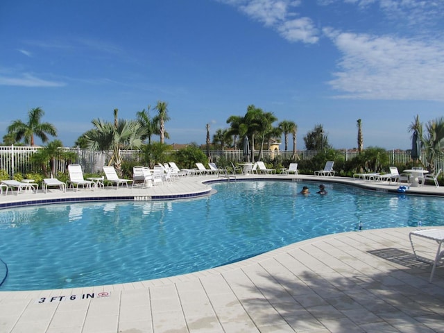 community pool featuring fence and a patio