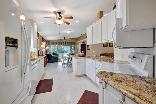 kitchen with a peninsula, white appliances, a ceiling fan, open floor plan, and light tile patterned floors