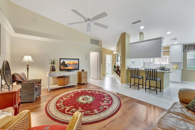 living area featuring light wood-type flooring, a ceiling fan, and visible vents