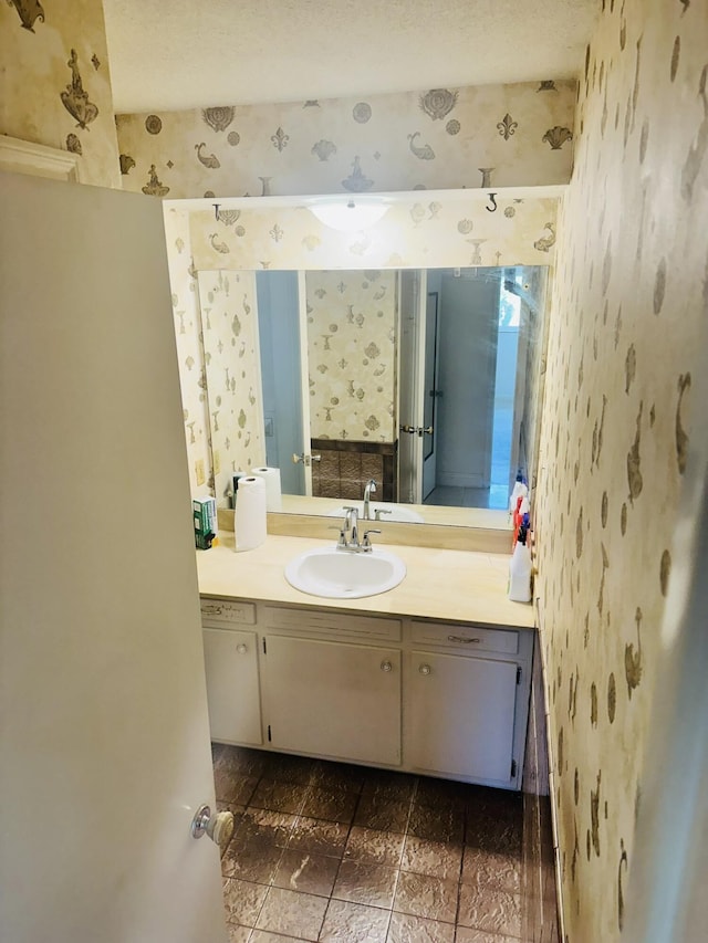 bathroom with vanity and wallpapered walls