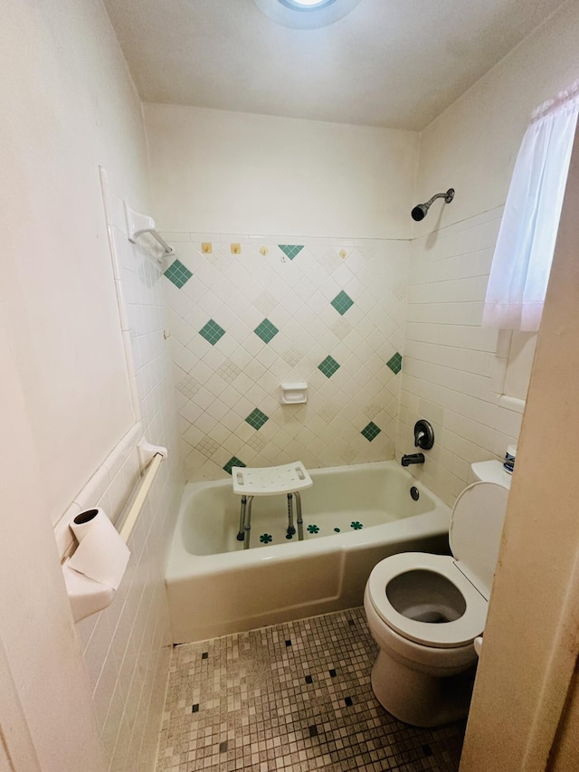 full bathroom featuring tile patterned flooring, toilet, and washtub / shower combination