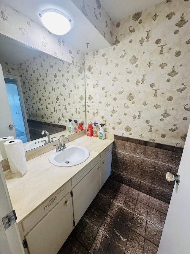 bathroom with vanity and wallpapered walls