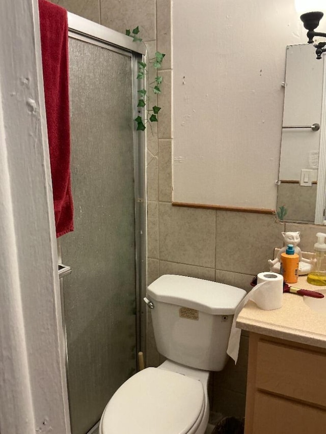 full bathroom featuring vanity, tile walls, toilet, and a stall shower