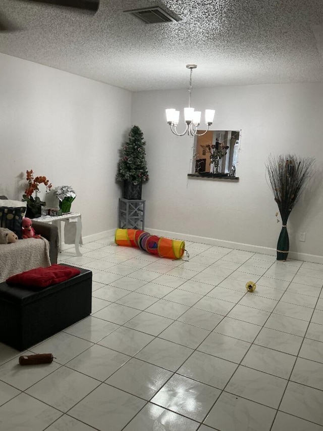 playroom with a notable chandelier, visible vents, a textured ceiling, and baseboards