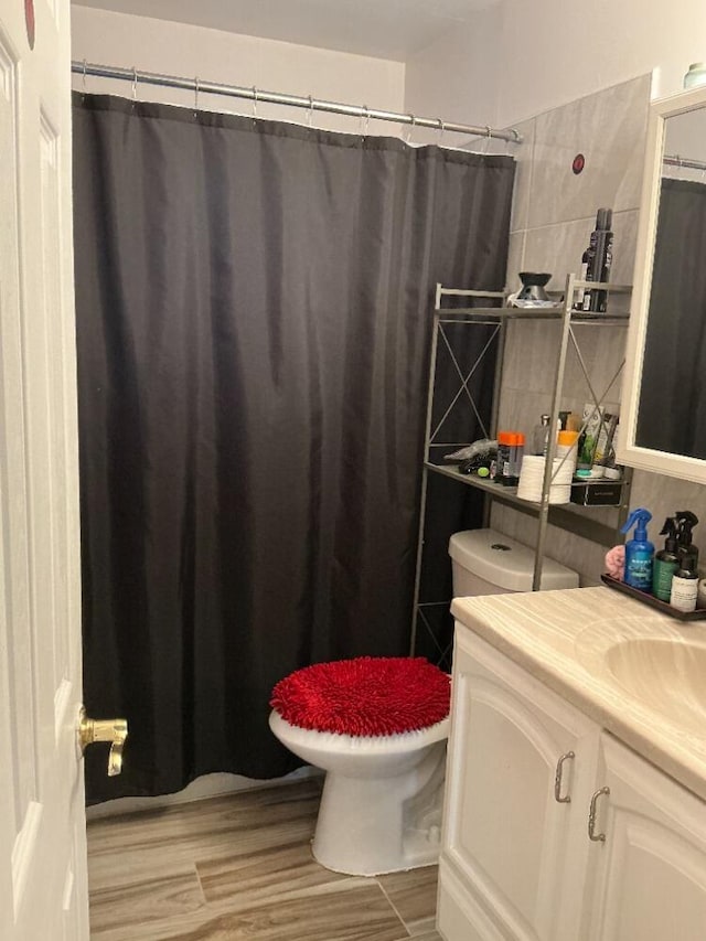 full bath with toilet, vanity, a shower with curtain, and wood finished floors