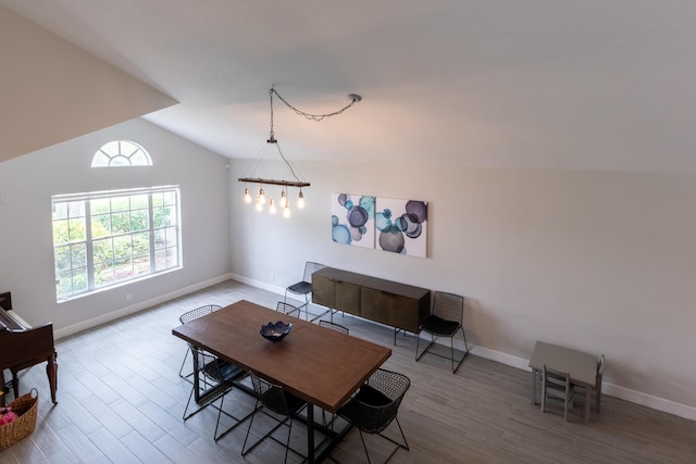 dining room featuring baseboards, wood finished floors, and vaulted ceiling