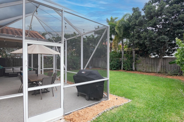 view of yard with a patio, a fenced backyard, and a lanai