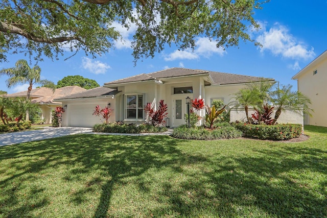 view of front facade featuring a front yard, stucco siding, concrete driveway, a garage, and a tile roof