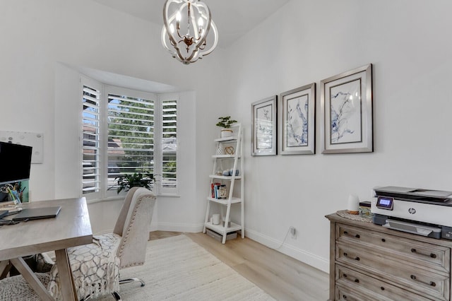 office area with light wood-style flooring, a notable chandelier, and baseboards