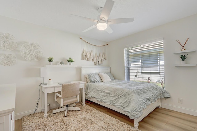 bedroom featuring light wood-style flooring, a ceiling fan, and baseboards