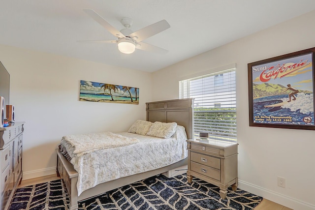 bedroom featuring wood finished floors, a ceiling fan, and baseboards