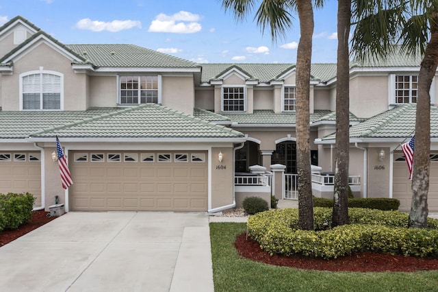 view of property featuring stucco siding, driveway, and a tiled roof