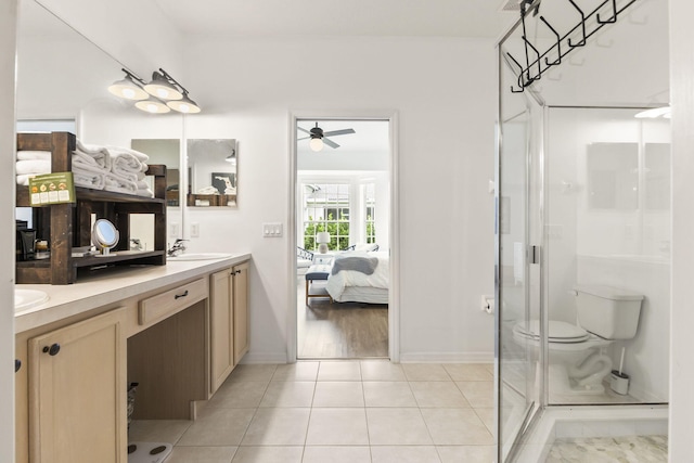 bathroom with a sink, connected bathroom, a shower stall, tile patterned flooring, and double vanity