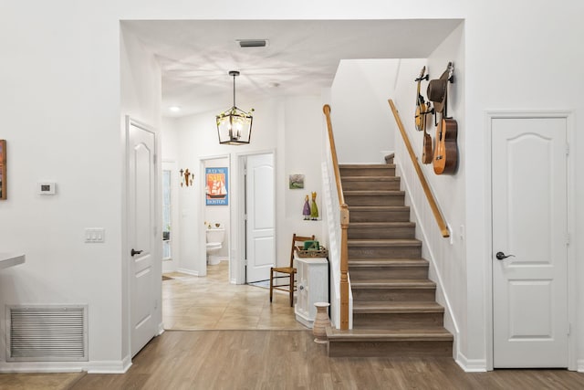 foyer featuring visible vents, light wood-style flooring, and stairs