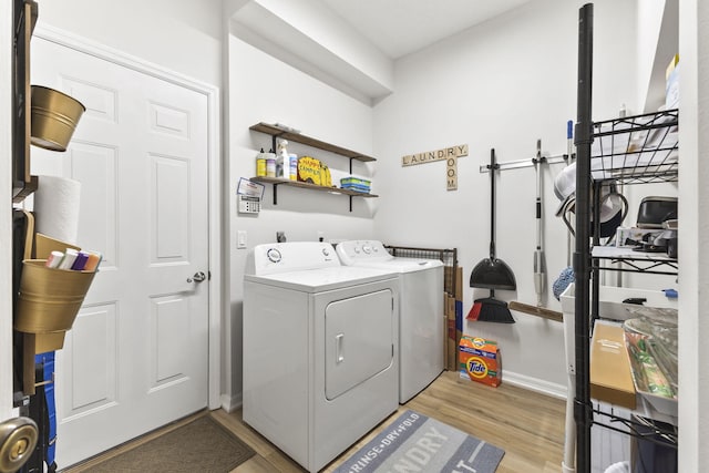 laundry area featuring light wood-type flooring, separate washer and dryer, and laundry area