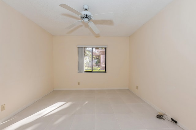 unfurnished room with baseboards, a textured ceiling, ceiling fan, and light tile patterned flooring