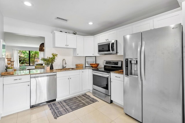 kitchen with visible vents, backsplash, stainless steel appliances, and a sink