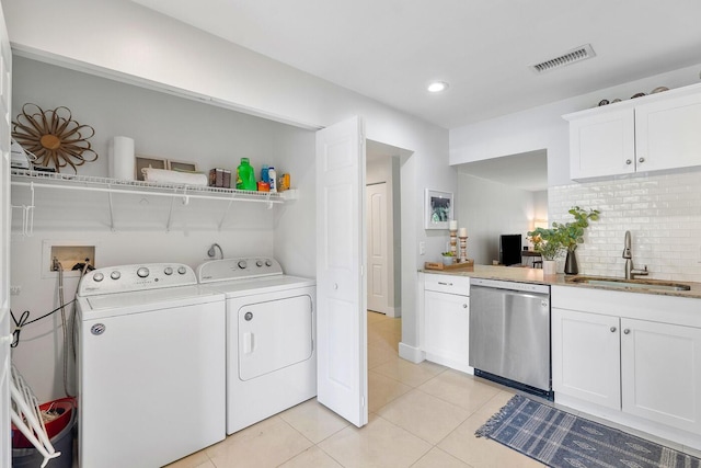 laundry room with visible vents, washer and clothes dryer, light tile patterned floors, laundry area, and a sink