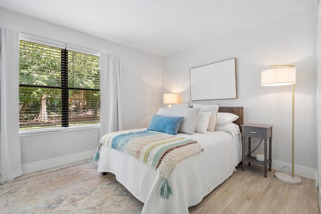 bedroom with baseboards and wood finished floors