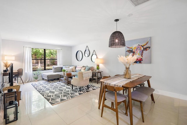 tiled dining room featuring baseboards and visible vents