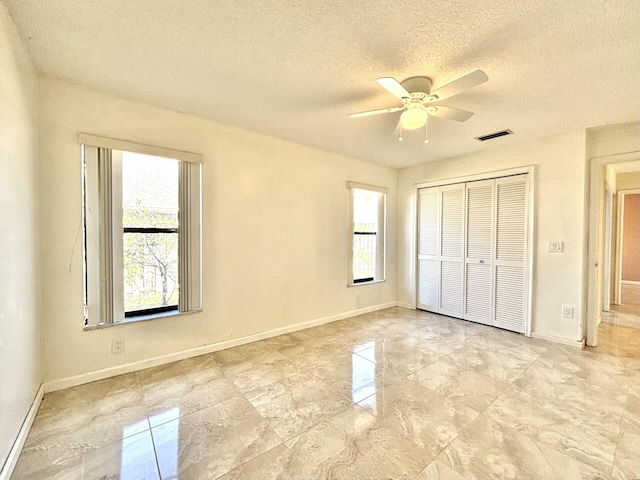 unfurnished bedroom featuring baseboards, visible vents, a closet, and a textured ceiling