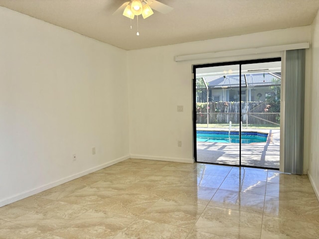 spare room with baseboards, a ceiling fan, and a sunroom