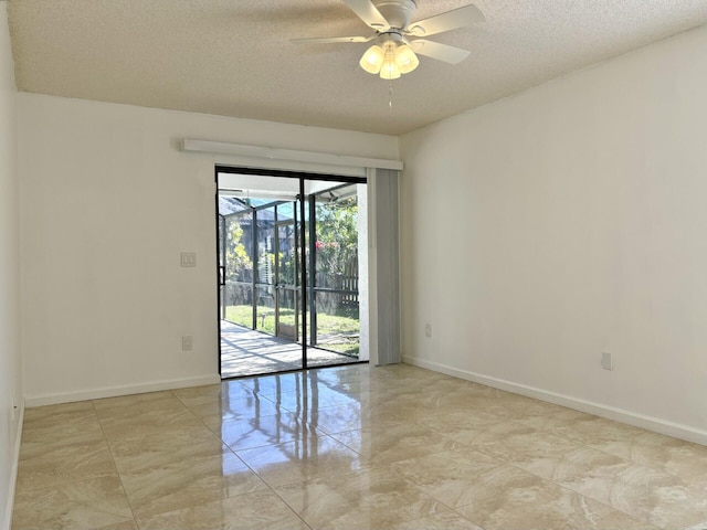 empty room with baseboards, a textured ceiling, marble finish floor, and a ceiling fan