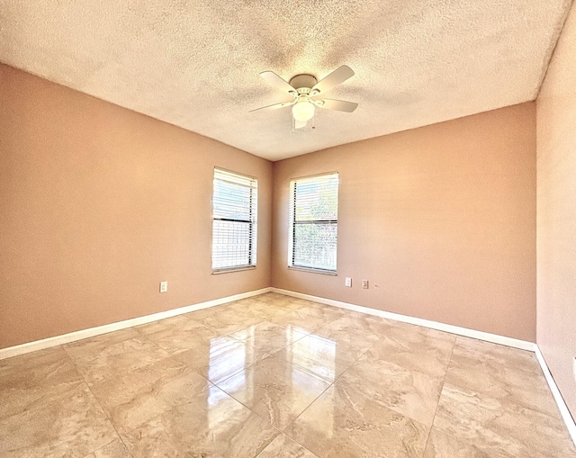 spare room featuring a textured ceiling, baseboards, marble finish floor, and ceiling fan