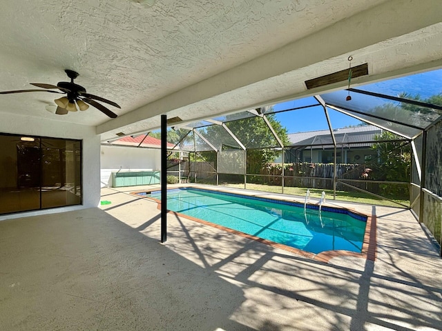 pool featuring ceiling fan, glass enclosure, and a patio