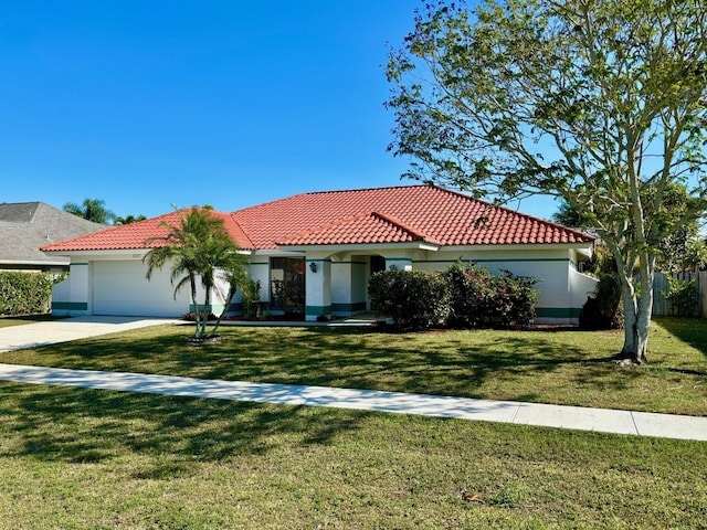 mediterranean / spanish house with stucco siding, a front lawn, concrete driveway, a garage, and a tiled roof