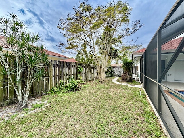 view of yard with glass enclosure and a fenced backyard