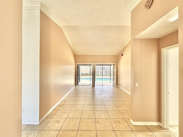 interior space with baseboards, a textured ceiling, ornamental molding, and light tile patterned flooring