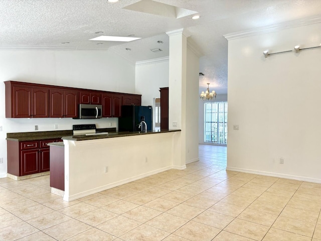 kitchen with dark countertops, freestanding refrigerator, ornamental molding, stove, and stainless steel microwave