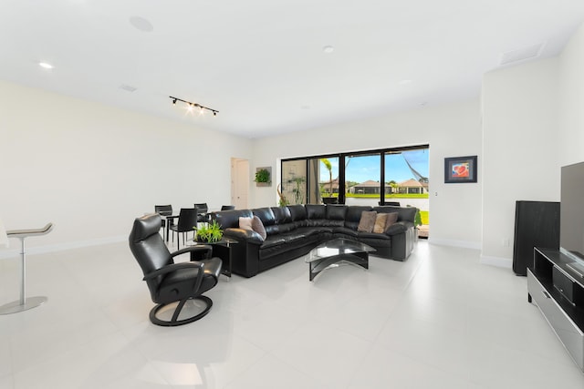 living room with visible vents, track lighting, and baseboards