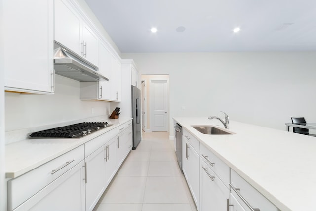 kitchen with a sink, stainless steel appliances, light countertops, white cabinets, and under cabinet range hood